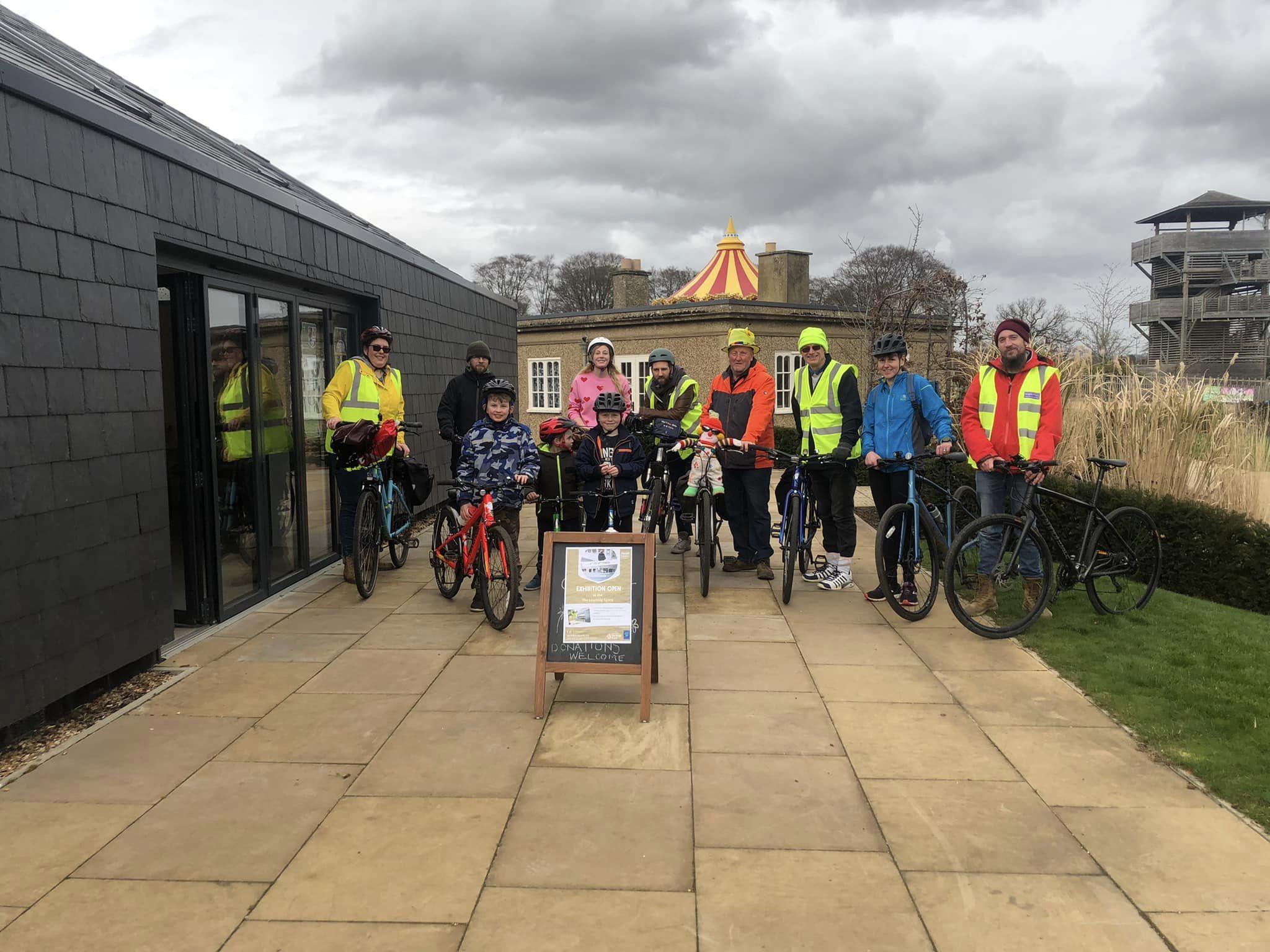 Group of cyclists in High Vis outside a cafe in a park