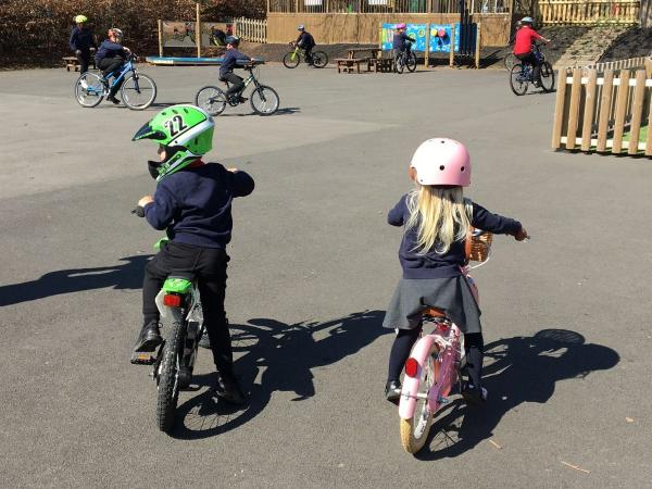 Kids with helmets on bikes.