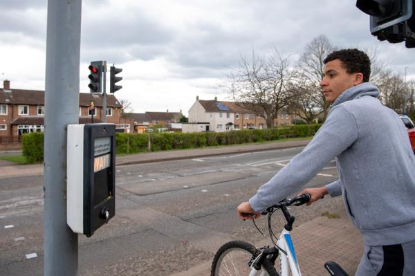 Boy on a bike crossing the road.