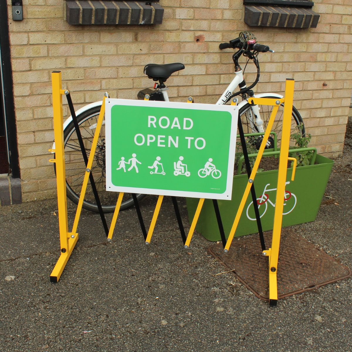 Road Open To Sign on Barrier with a bike behind