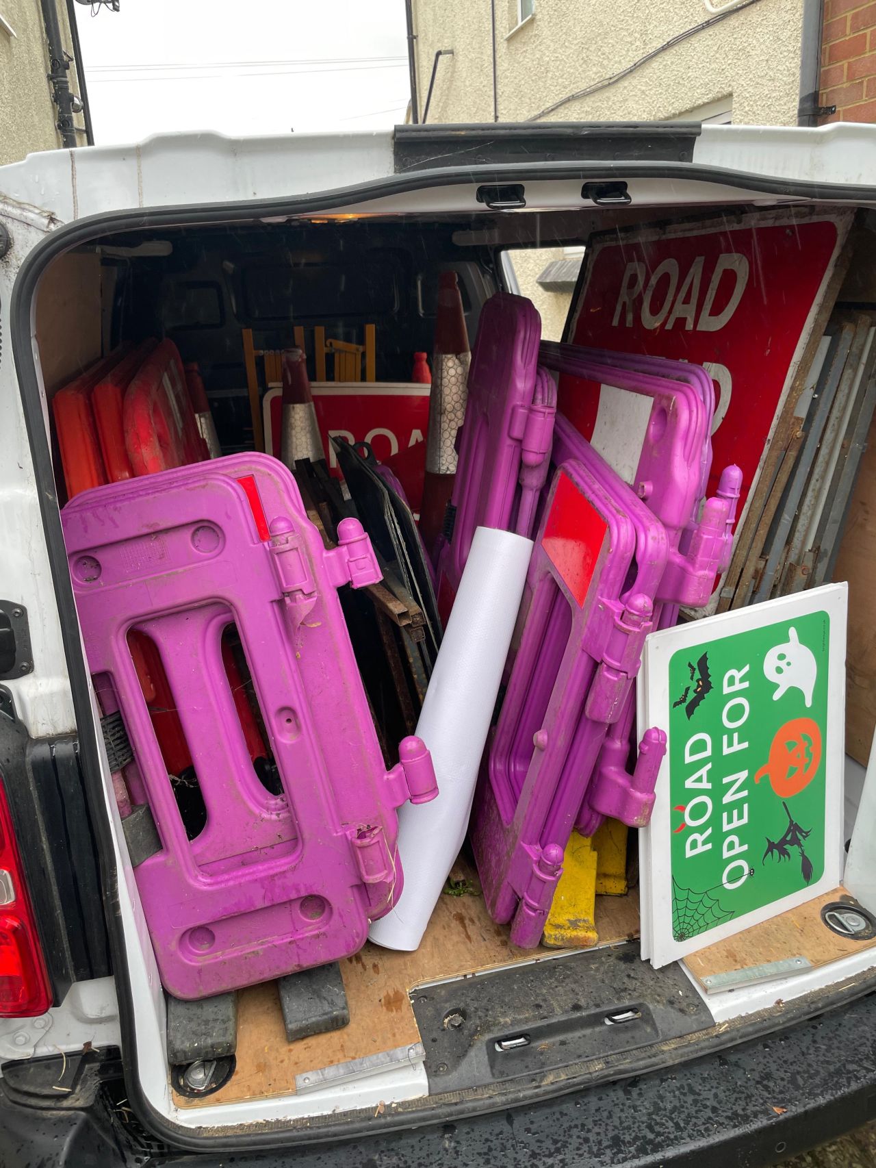 Van with road closed signs and barriers.