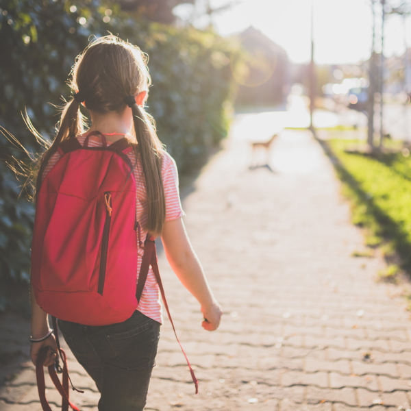 GIrl with backpack walking to school.